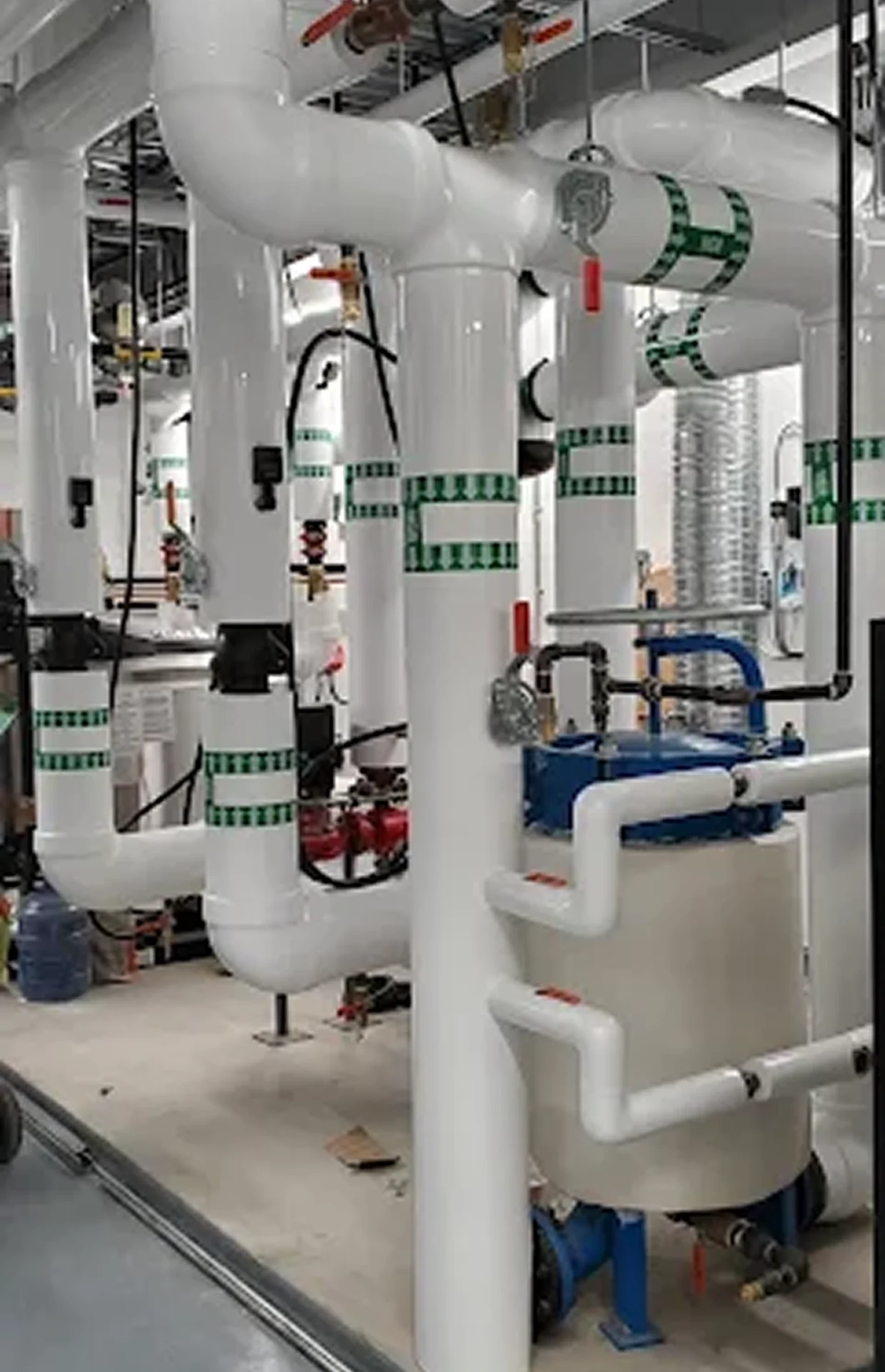 Industrial pipes and valves in mechanical room.