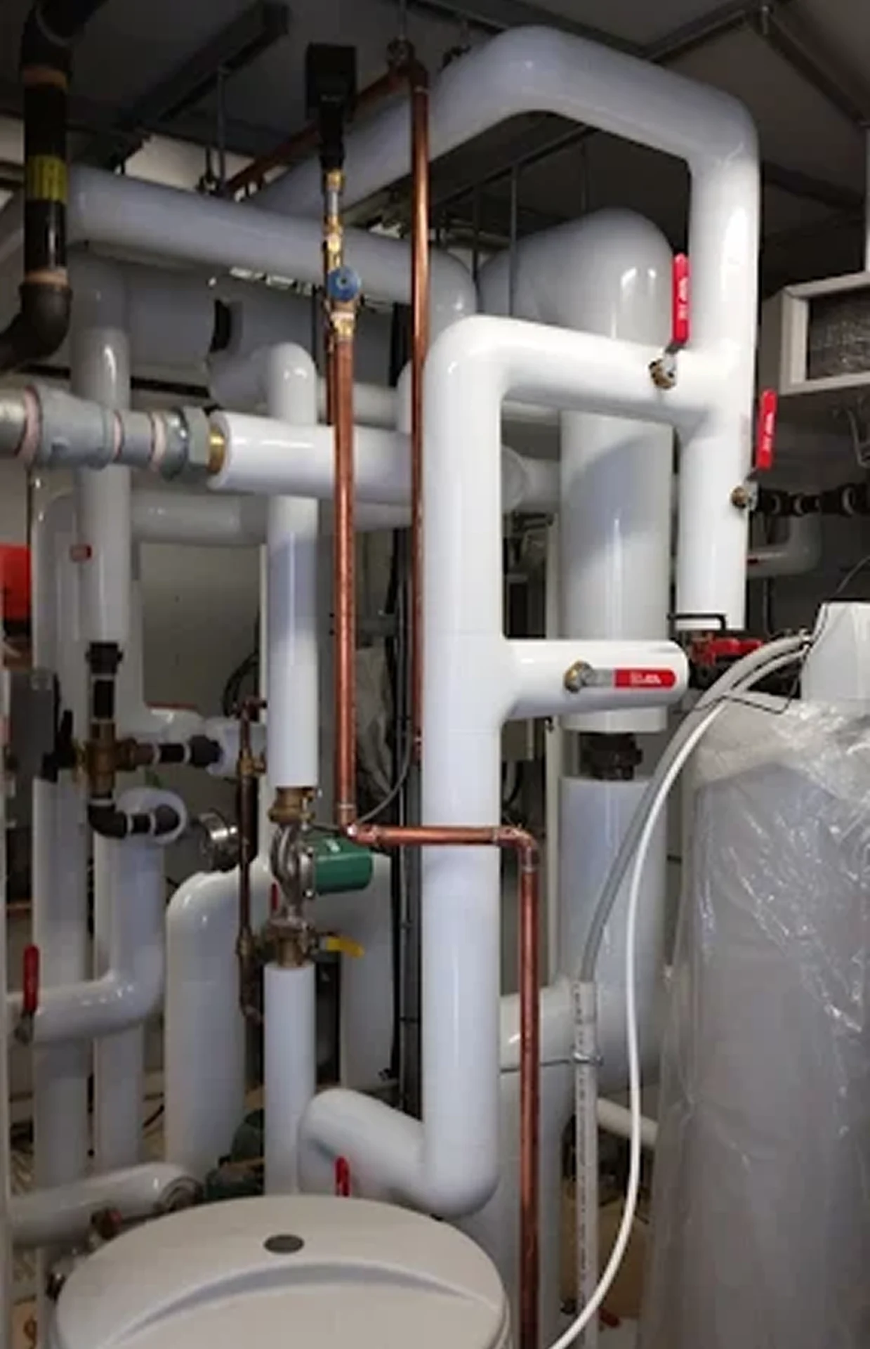 Industrial pipes and valves in a boiler room.