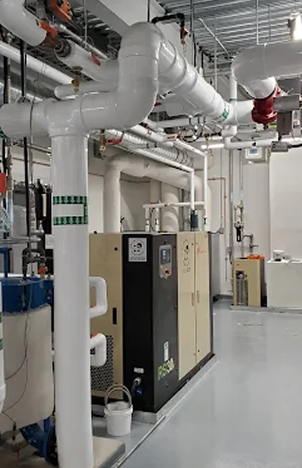 Industrial room with pipes and machinery.