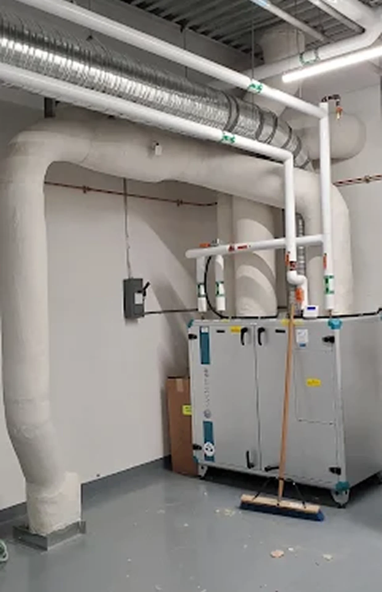 Industrial pipes and ventilation system in room.